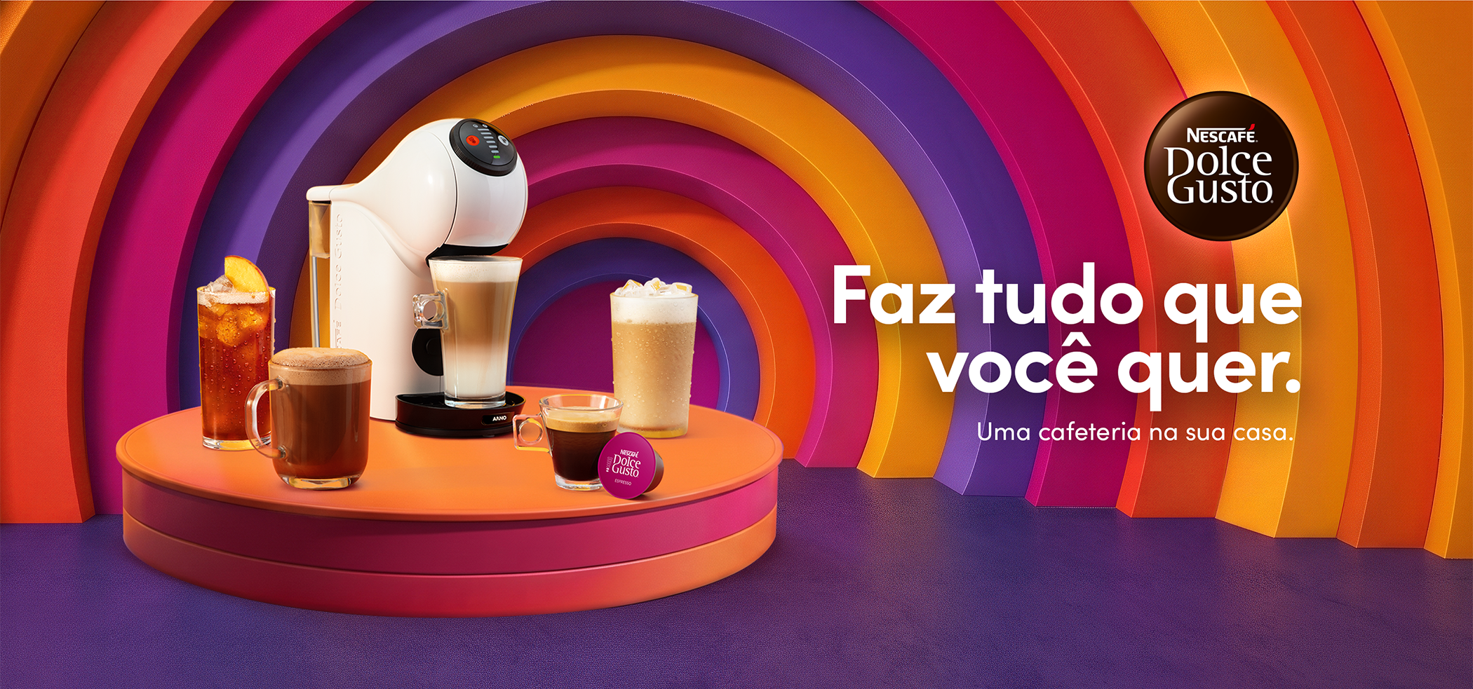 Descubra Nescafé Dolce Gusto e tenha uma cafeteria na sua casa! Banner da Nescafé Dolce Gusto com cafeteira de cápsulas branca, cápsula e diferentes bebidas quentes e geladas. Texto: “Faz tudo que você quer. Uma cafeteria na sua casa.