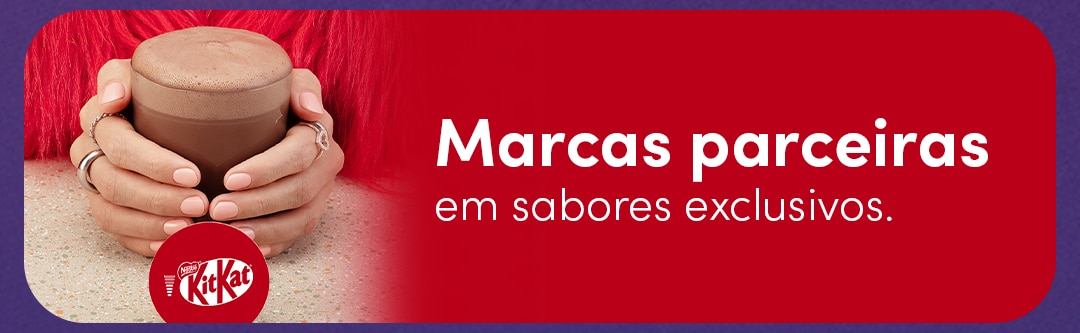 Descubra sabores exclusivos de marcas parceiras Nescafé Dolce Gusto como KitKat Banner de marcas parceiras da Nescafé Dolce Gusto com uma pessoa segurando uma xícara de bebida e o logotipo KitKat. Texto: “Marcas parceiras em sabores exclusivos